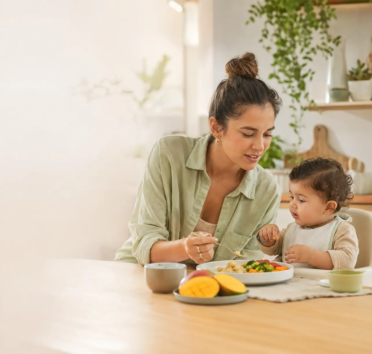 Mãe conduzindo a alimentação do filho com cuidado durante uma refeição